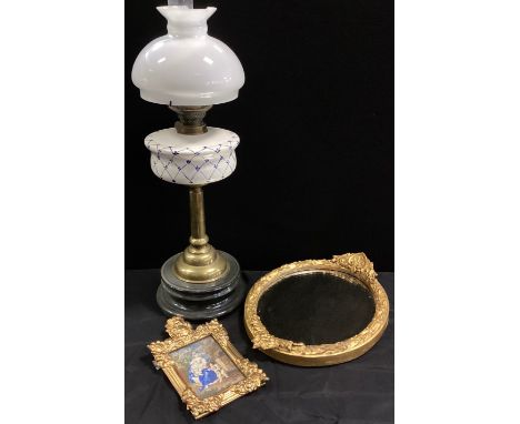 A 20th century brass oil lamp, blue and white ceramic reservoir, white shade, wooden plinth, 72cm high, gilt mirror, 41cm lon