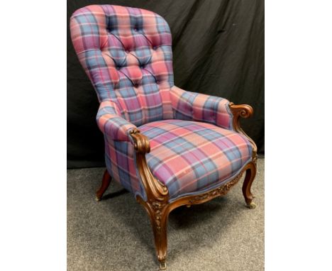 A Victorian walnut armchair, button-back, scroll arms, carved cabriole legs, brass casters, 104cm high x 67cm wide. 