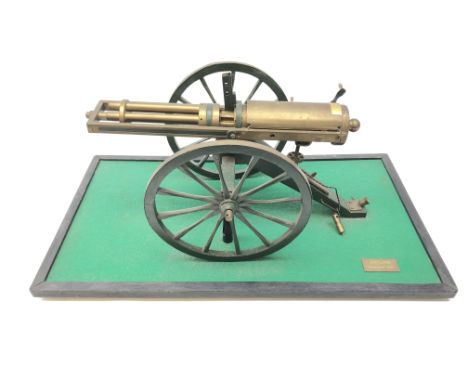 Scratch built brass model of an 1861 Gatling Gun with rotating barrels, hinged cover revealing mechanism, on metal bound wood