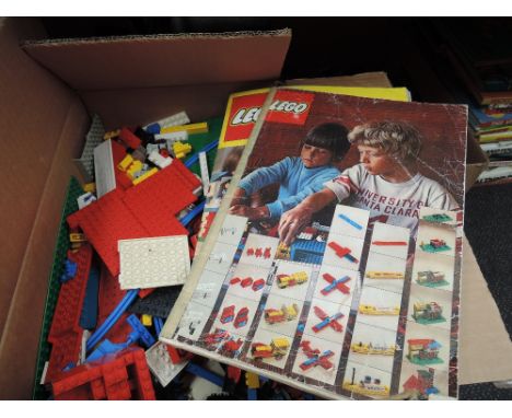 A box of vintage Lego and two booklets
