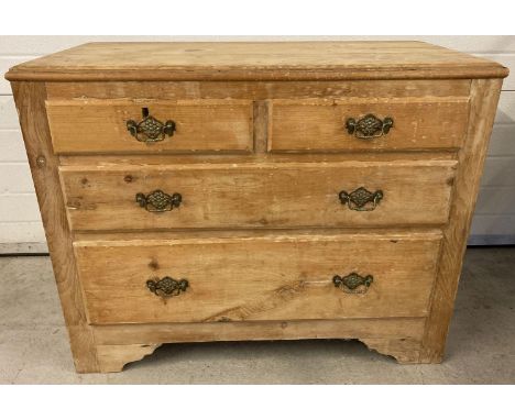 A vintage light wood 4 drawer chest of drawers with decorative brass drop down handles. 