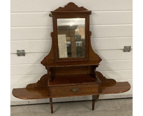 An antique decorative wall hanging over mantle mirror with shelving and single drawer. 