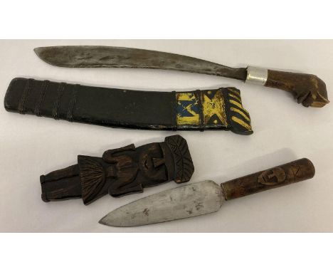 2 vintage wooden handled knives. A tribal dagger style knife with carved detail to handle and sheath together with a larger w