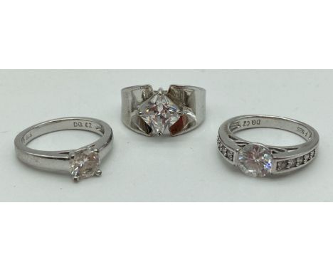 3 stone set silver solitaire style dress rings. One with central round cut clear stone, one with central square cut clear sto