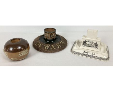 3 antique ceramic advertising match strikers/holders, 2 by Royal Doulton. A Dewar's Whisky match striker with Royal Doulton m