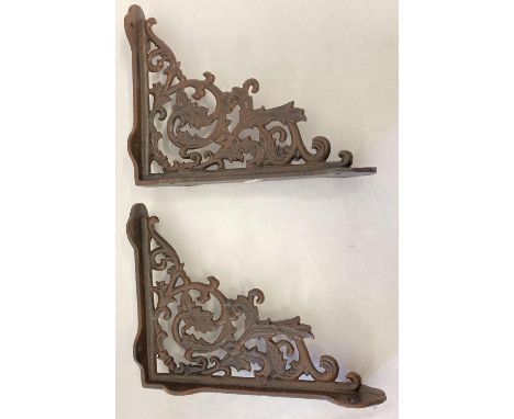 A pair of rust effect cast metal wall shelf bracelets, with decorative scroll &amp; leaf design. Approx. 28.5cm x 23cm. 