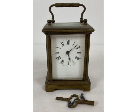 A small antique brass and glass panel carriage clock with white enamel face. Complete with key. Working order. 