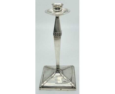 An Arts &amp; Crafts silver candlestick with studded detail, square shaped base &amp; circular bobeche. Fully hallmarked Henr