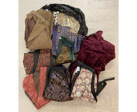 A bag of assorted vintage clothing to include waistcoats and jackets. 