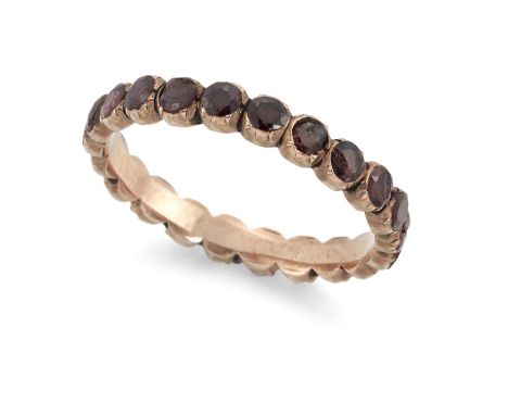 A 19th century gold garnet eternity ring, composed of a single line of facetted garnets (one lacking, some later replacements