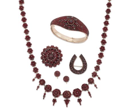 A suite of late 19th/early 20th century Bohemian garnet jewellery, comprising a graduated cluster panel necklace with graduat