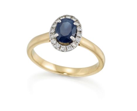 An 18ct gold sapphire and diamond cluster ring, the oval mixed cut sapphire to brilliant cut diamond surround, and plain hoop
