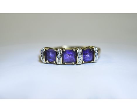 Ladies 9ct Gold Diamond and Amethyst Chanel Set Ring. The Three Amethysts of Good Colour with Diamond Spacers. Marked 375. Ri