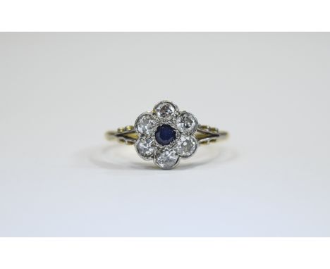 18 ct Gold Set Sapphire And Diamond Cluster Ring Flower head setting. The central Sapphire surrounded by six diamonds, marked