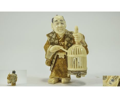 Japanese Very Finely Carved and Signed 19th Century Ivory Netsuke of a Japanese Man Holding a Large Bird Cage, Dressed In Fin