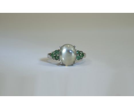 Green Moonstone and Emerald Ring, an oval cut, 3ct cabochon of green moonstone, flanked by .25ct of round and square cut emer