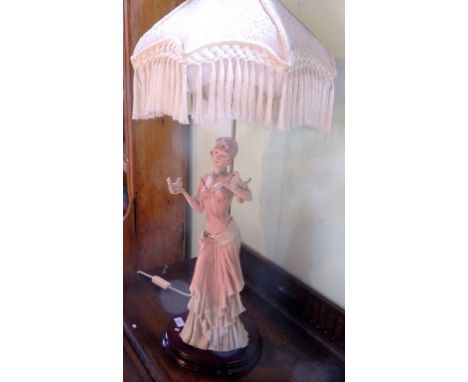 A contemporary table lamp form as a tall elegant lady holding two doves, mounted on triangular wood stand (94cm to include sh