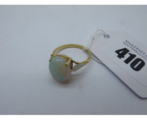 A 18ct Gold Single Stone Opal Ring, the oval cabochon four claw set, between two colour shoulders, stamped makers mark "W.T.T