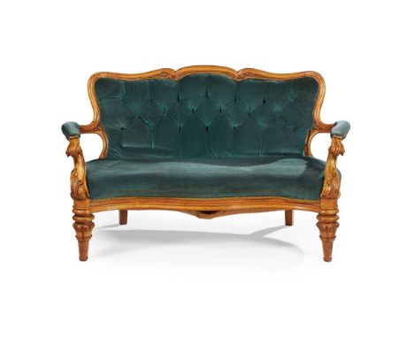 the button upholstered back above a serpentine seat and part padded open arms, raised on turned and foliate carved legs, in b