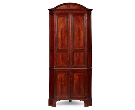 the arched moulded cornice above a pair of ebony banded panel doors opening to a grey painted interior with shaped shelves; t