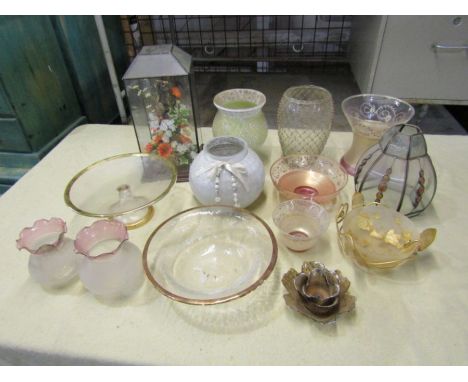 Glass vases, bowls, vintage lamp shades and flower arrangement in glass case&nbsp;
