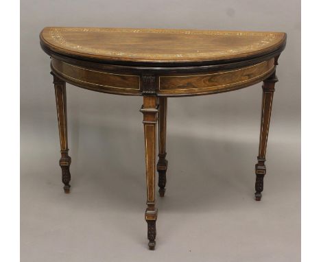 A LATE 19TH CENTURY ROSEWOOD DEMI-LUNE CARD TABLE, the top with boxwood and ivory inlay enclosing a baize-lined interior, on 