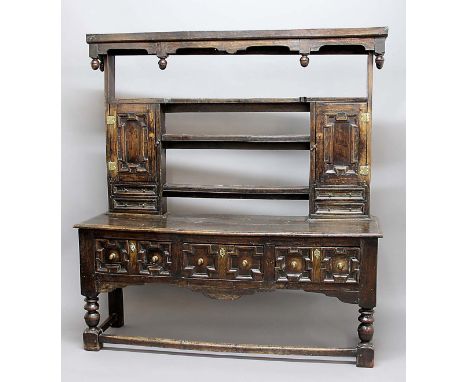 17TH CENTURY OAK DRESSER, the three shelf plate rack with a pair of geometrically moulded doors with brass butterfly hinges a