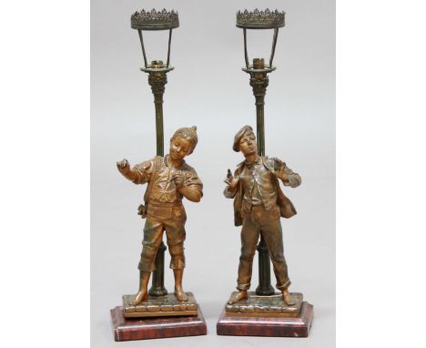 PAIR OF BRONZED SPELTER FIGURAL LAMPS, early 20th century, modelled as street boys before a lamp, on mottled red marble bases