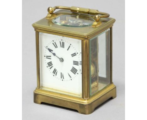 BRASS FOUR PANE CARRIAGE CLOCK, with an enamelled dial on an eight day movement half hourly striking to a gong, with leather 