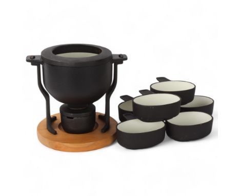 Digsmed Design, Denmark, a cast iron fondue set with white enamel interior and beech wood base, makers marks to base, numbere