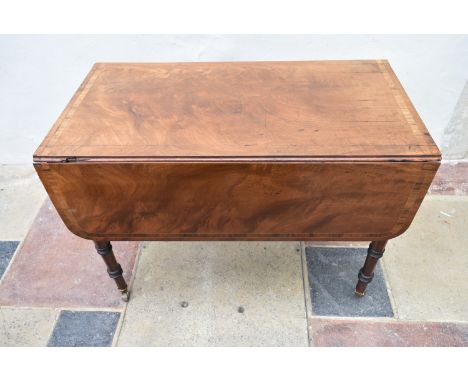 A Regency figured mahogany and rosewood crossbanded Pembroke table on ring turned tapering supports terminating in brass cup 