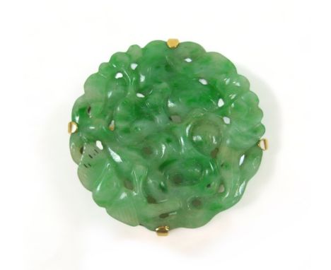 A carved green jade brooch in an Egyptian yellow gold 625 setting, 3cm diameter, 8.7 grams.Slight bending to pin otherwise ge