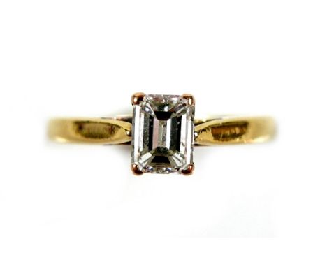 An 18ct yellow gold and diamond solitaire ring, the emerald cut stone, 1.2ct, 5.5 by 4.3 by 2.9mm, in four claw setting to a 