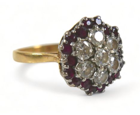 An 18ct diamond and ruby cluster ring, with seven round cut diamonds to its centre, each stone approximately 3.5mm diameter, 