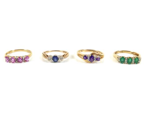 A group of four 9ct gold and diamond rings, comprising a 9ct gold and green oval emerald stone ring with four pairs of small 