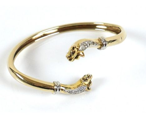 A yellow gold open torc style bangle, formed with a panther's head at each end, set with small diamonds, band 5mm wide, heads