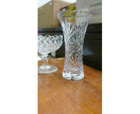 Cut glass cylindrical flower vase, glass perfume bottle and a sugar basin on circular plinth