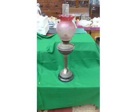 Most ornate table lamp twist stem supports on circular base with decorative etched cranberry glass shade