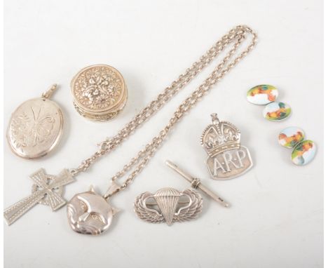 A collection of jewellery and badges, an oval silver locket, ankh cross and chain, novelty cat locket, pill box, pair of enam