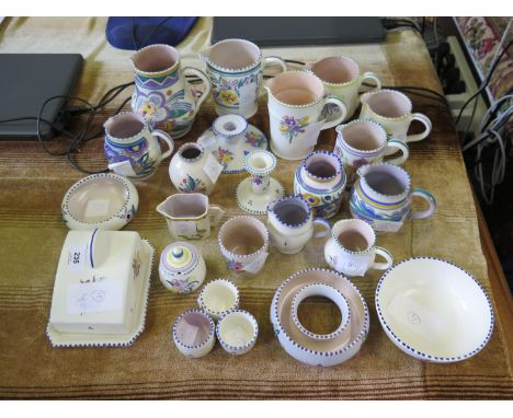 A collection of Poole Pottery, including jugs (largest 14.5 cm), covered cheese dish, candlesticks and bowls, all with floral