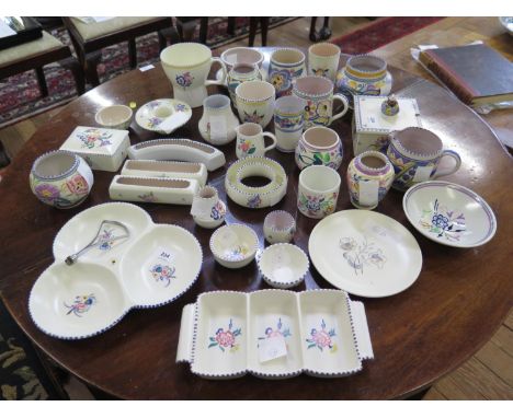A collection of Poole Pottery, including small vases, jugs, boxes and serving dishes, all with floral designs 