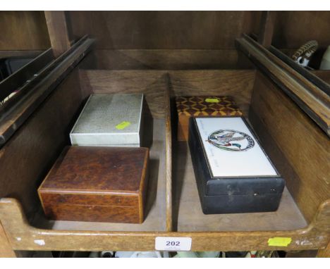 A shagreen covered cigarette box, 15 cm wide, another in amboyna, a leather covered cigarette box with painted ceramic plaque
