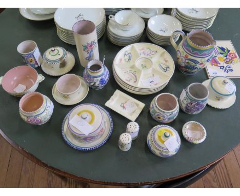 A collection of Poole Pottery, including a tile, plates, covered dishes, jars and an ashtray, all with floral designs 