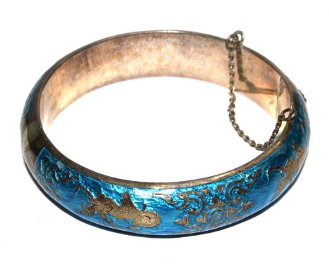 A Far Eastern bangle finished with blue enamel 
