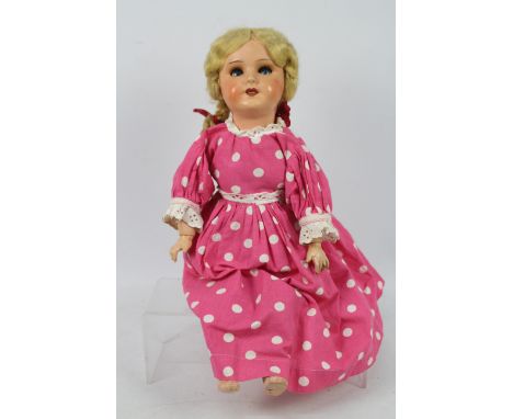 Unis - A vintage Unis France composite doll with blue sleeping eyes and open mouth showing upper teeth. She stands 48 cm tall