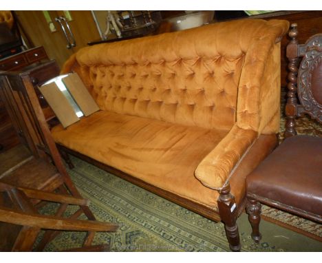 An Edwardian Mahogany framed four seater Sofa/Settle upholstered in gold/brown draylon fabric, the back rest being buttoned, 