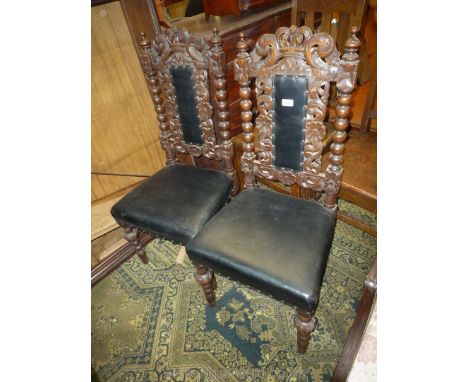 A pair of carved Oak framed Hall Chairs having top rails incorporating a crown, bobbin turned side supports, turned front leg