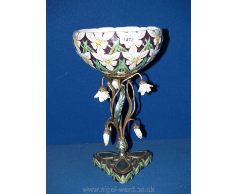 A ceramic and metal table centre piece with profuse daisy flower decoration on twisted stem metal stand.