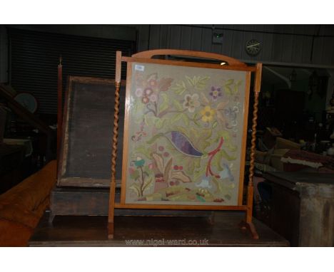 A light Oak framed Firescreen having delicate twist side supports, the panel decorated with needlework depicting stylised flo