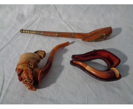 Two Meerschaum Pipes and an Oriental pipe. Meerschaum pipe: L10cm. Meerschaum pipe with carved hear: L14cm. Oriental Pipe: L2
